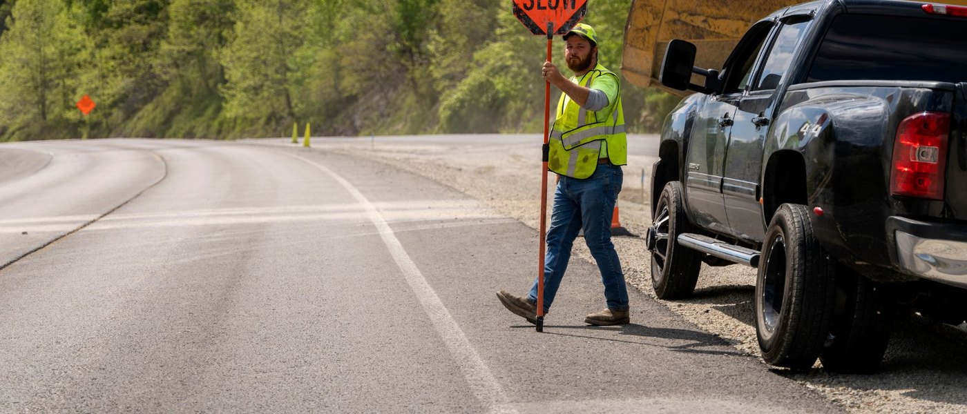 Road worker holding a slow sign in a work zone