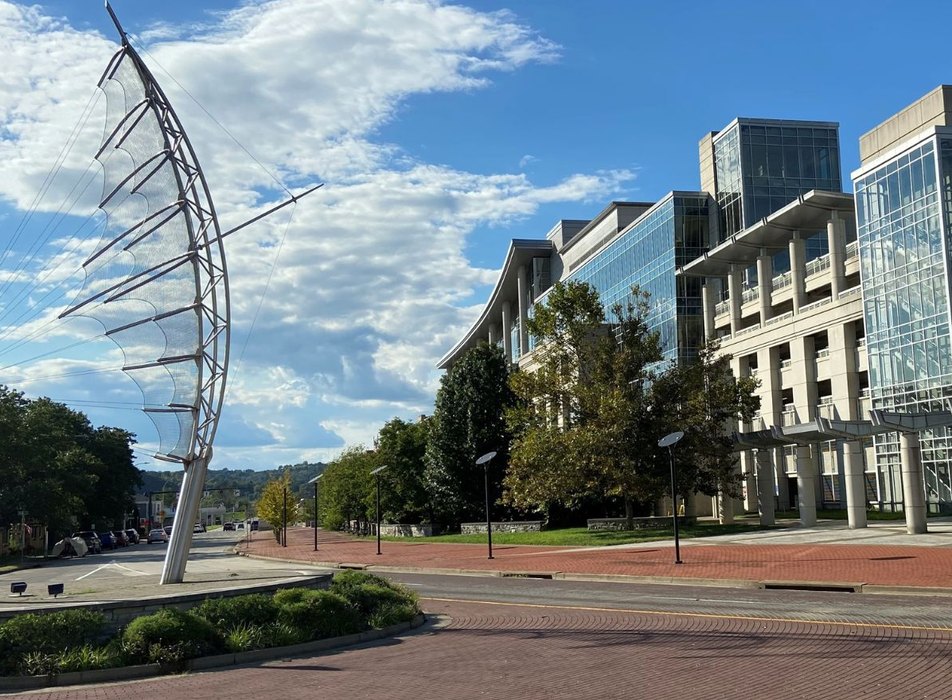 City buildings and public art under a blue sky